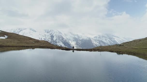 Karlı Annapurna dağına karşı Highland Gölü 'nde iki kişi duruyor. — Stok video