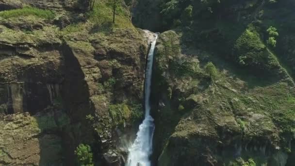 Широкоугольный вид с воздуха на водопад, падающий в глубокое ущелье реки — стоковое видео