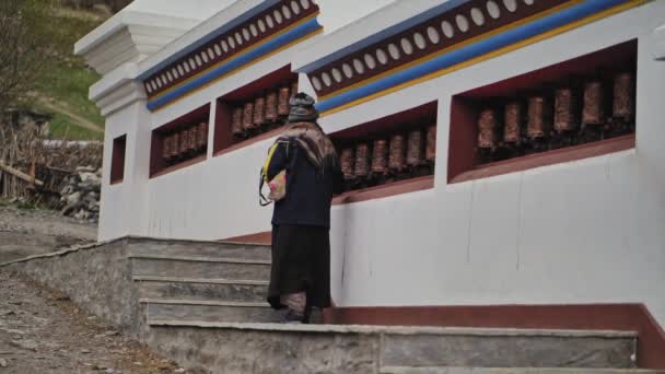 尼泊尔曼农附近的佛教寺院，朝圣者上楼去，旋转着祈祷轮 — 图库视频影像