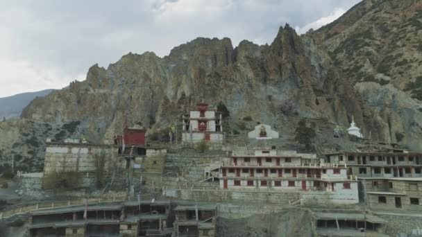 Luchtvlucht bij leeg winderig Braga klooster genesteld onder kuifkliffen, Nepal — Stockvideo