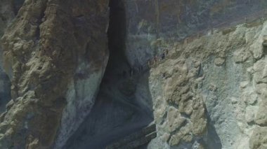 Gezginler dar yolda ilerler, dağlık arazide kayalık uçurumlar, Nepal