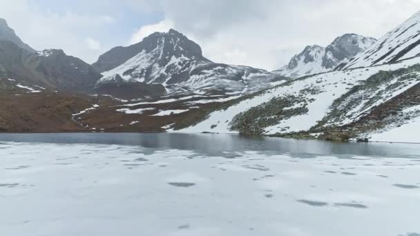 Vlucht over ijsschots op hoogland meer, reflecties van sneeuwtoppen op water, Nepal — Stockvideo