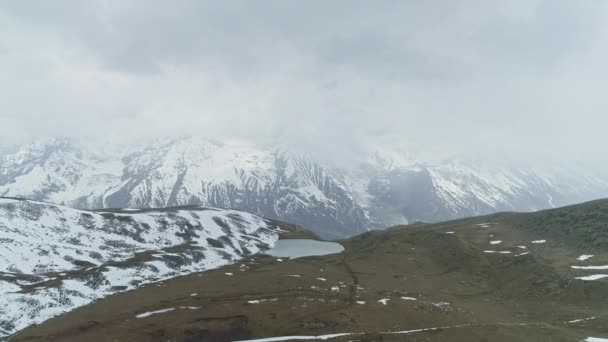 Vogelperspektive, Hochlandsee auf Hochebene, verschneite Annapurna in starken Wolken versteckt — Stockvideo