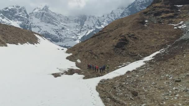 Turister vandring över stenig sluttning, expedition till snöiga Annapurna Iii berg — Stockvideo