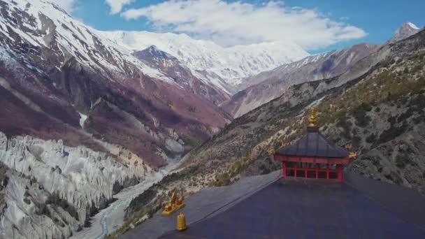 Techo de pagoda roja, impresionante valle de la montaña, nevado pico Tilicho en el horizonte, Nepal — Vídeo de stock