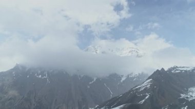 Yüksek irtifa, kayalık tepeler yakınında yükselir, bulutlar karları gizler Annapurna dağı, Nepal 