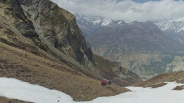 Turistler, kar yamacında yolculuk, şiddetli dağlık arazi manzarası, Nepal 