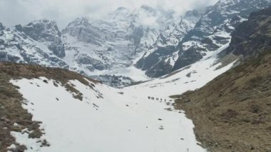 Turistler, görkemli dağların, dağlık dağların, Nepal 'in dağlık kesişiminin kar ayağına doğru yürüyorlar.