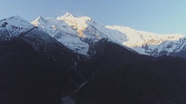 Kara yamaçların üzerindeki dev dağ zirvesinde sihirli bir parıltı.