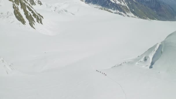Turistlerin üzerindeki hava sineği geniş kar yamacına tırmanıyor, dağ gezisine. — Stok video