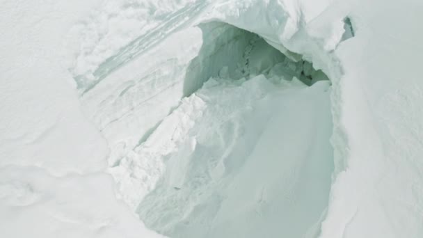 Grande caverna desmoronada na neve eterna grossa profunda, perigo de avalanche em montanhas — Vídeo de Stock