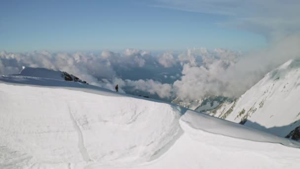 Impresionante panorama, alpinistas en la cima de la nieve, cumbre de la montaña por encima de las nubes — Vídeos de Stock