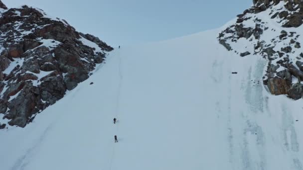 Alpinistas sobe sobre enorme parede de neve íngreme, obstáculo em um caminho para o pico alto — Vídeo de Stock