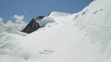 Dağlık arazi, yükselen dağcı yolu, kar buzulu dağ yamacında.