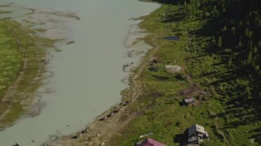 Hava manzarası, at binicileri orman turist üssündeki sütlü gölde yürüyor.