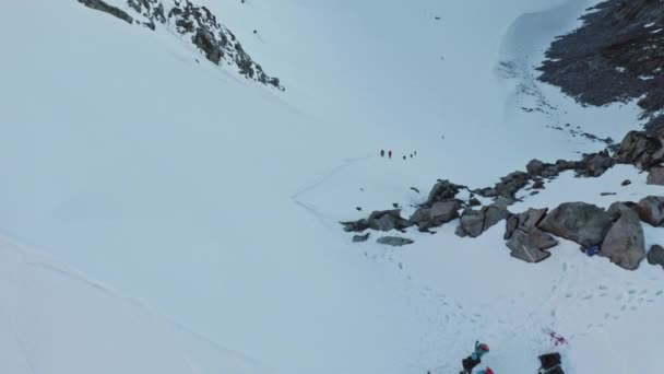 Gli alpinisti si arrampicano su un enorme pendio di montagna, a fatica attraverso un sacco di neve — Video Stock