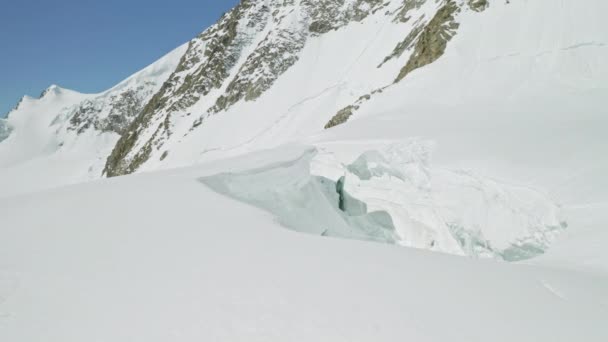 Csodálatos hegyvidéki panoráma, széles összeomlott üreg sűrű hóban a hegylábaknál — Stock videók