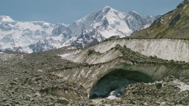 Grotte du glacier Akkem couverte de éboulis, l'eau de fonte coule sous la glace de dégel — Video