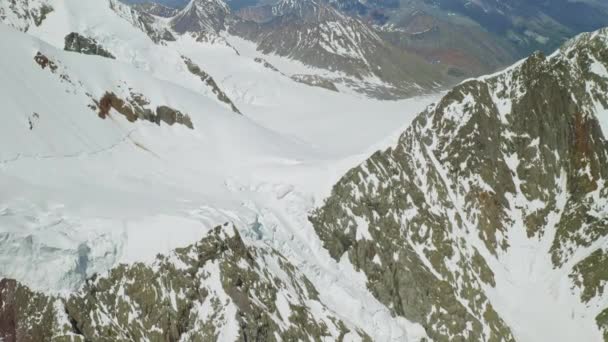 Mosca aérea acima da paisagem montanhosa, muita neve eterna nas encostas das montanhas — Vídeo de Stock