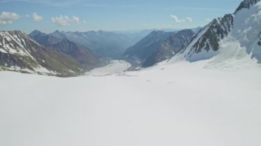 Alp manzarası, el değmemiş geniş kar tarlası, dağ vadisinde büyük bir buzulun dili.