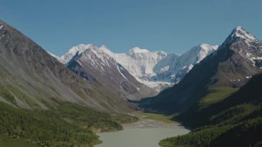 Geniş hava manzarası, karlı beyaz Belukha Dağı sütlü Akkem Gölü 'nün üzerinde yükseliyor.