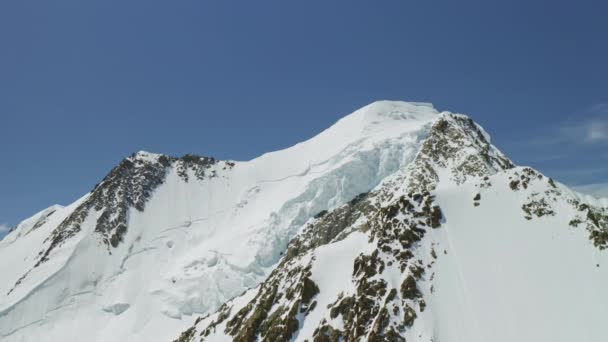 Велична високогірна панорама, біла вершина гір, затиснутий глибокий сніг на схилах — стокове відео