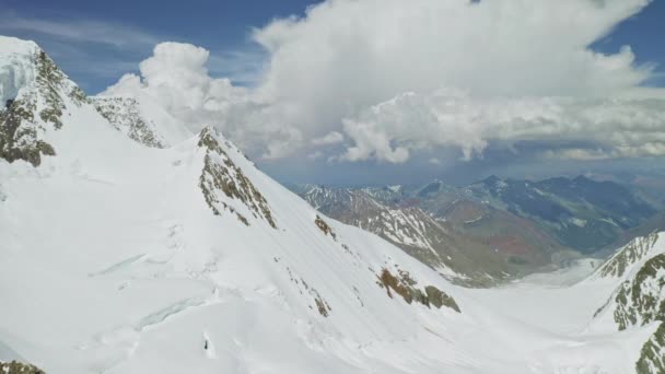 고산 지대의 파노라마, 비탈에 쌓인 많은 눈, 산맥 위의 구름 — 비디오
