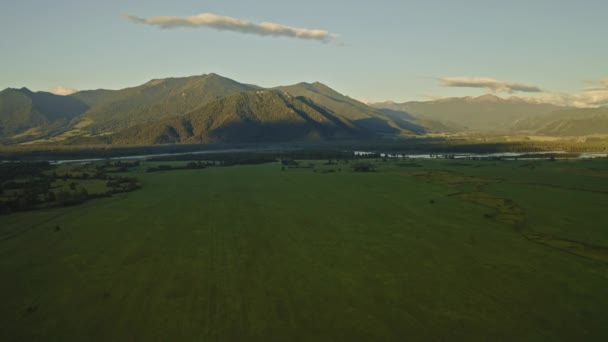 Salida del sol, panorama, amplio valle verde, río, luz dorada, sombras sobre colinas forestales — Vídeo de stock