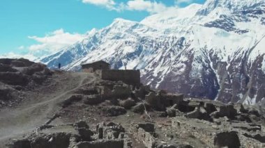 Dev kar dağı yakınlarındaki kayıp dağlık köyün kalıntılarında yürüyen turistler
