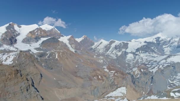 Niesamowita panorama góralska, śnieżnobiałe szczyty górskie dotykają chmur na błękitnym niebie — Wideo stockowe