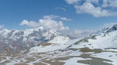 Highland Panorama, beyaz tepeler mavi gökyüzünde bulutlara dokunur, yerdeki karlı desen
