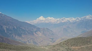 Yüksek irtifa panoraması, karlı Dhaulagiri Dağı ve ufukta Tukuche Tepesi.