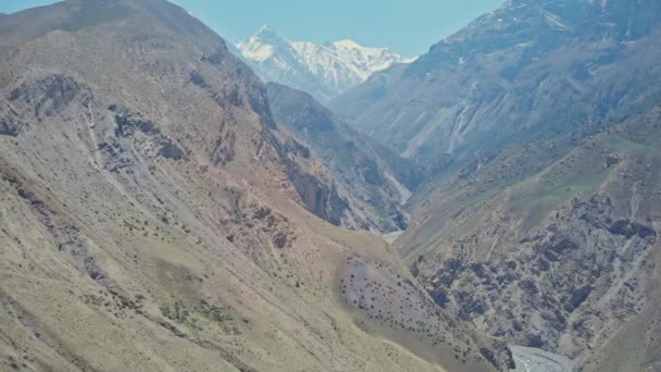 Panorama de alta altitude, garganta rochosa profunda gigante com picos cobertos de neve no horizonte — Vídeo de Stock