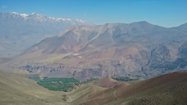 Panorama de alta altitude, campos de oásis verdes brilhantes em torno de encostas rochosas desertas — Vídeo de Stock