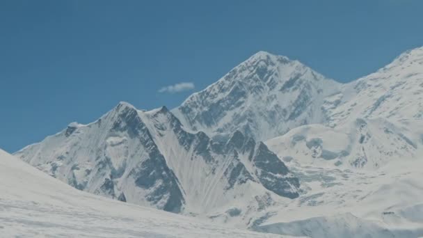 Ostre śnieżnobiałe wysokie szczyty górskie masywu Annapurna świecą na słonecznym błękitnym niebie — Wideo stockowe