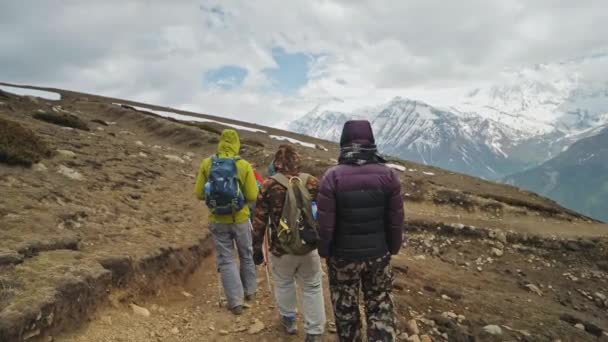 Turistická výprava po skalnatých horách u sněhového masivu v oblacích — Stock video