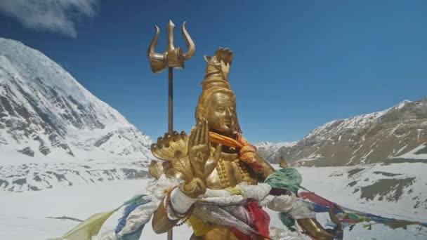 Golden statue of Lord Shiva shine at snowy Himalayas highlands against blue sky — Stock Video