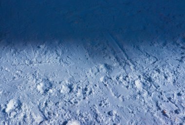 Yarı gölgeli, yarı aydınlık, karla kaplı topraklar.