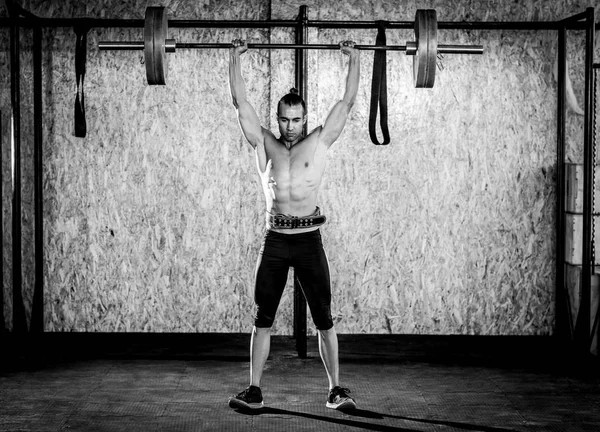 Joven musculoso en gimnasio — Foto de Stock