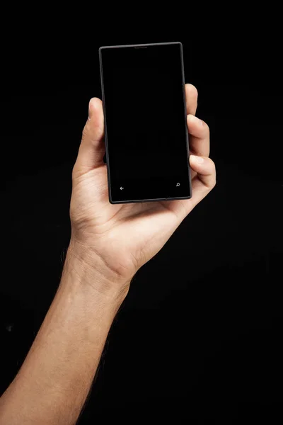 Homem com celular em mãos sobre fundo preto — Fotografia de Stock