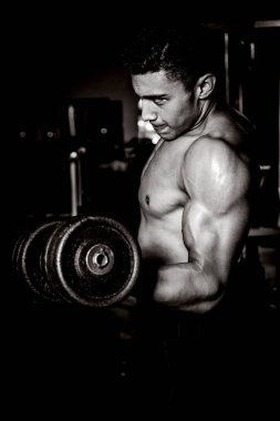 Genç adam karanlık ve yaşlı spor salonunda egzersiz yapıyor.