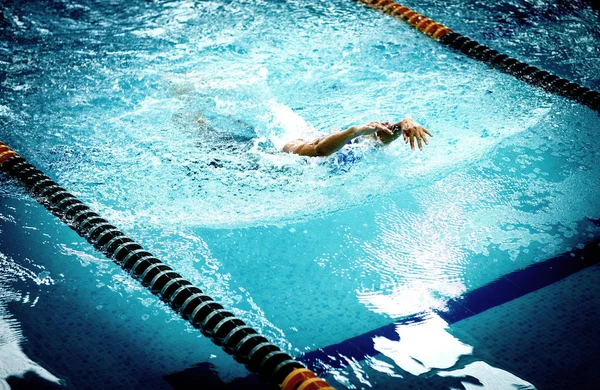 Young athletic man with butterfly swimming technique.