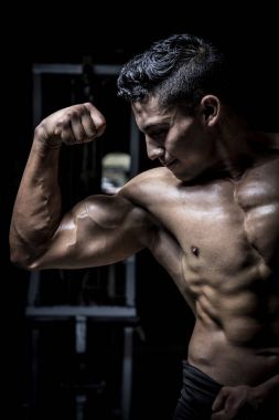 Genç adam karanlık ve yaşlı spor salonunda egzersiz yapıyor.