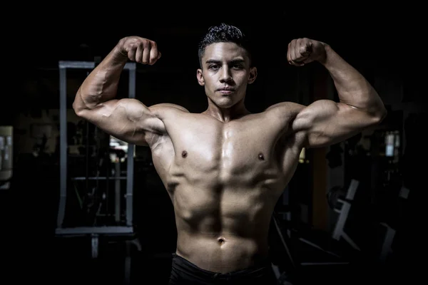 Hombre joven haciendo ejercicio en el gimnasio oscuro y viejo —  Fotos de Stock