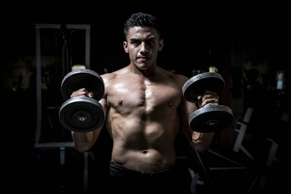 Junger Mann trainiert in dunklem und altem Fitnessstudio — Stockfoto