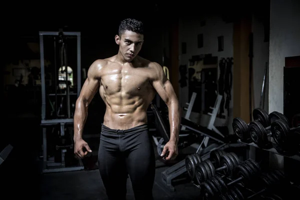 Młody mężczyzna ćwiczący w ciemnej i starej siłowni — Zdjęcie stockowe