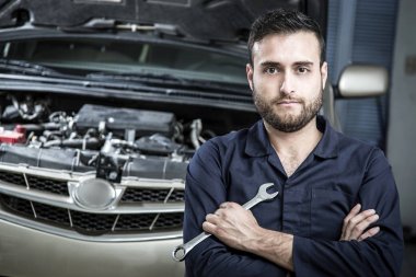 Garajdaki tamirci motoru tamir ediyor.