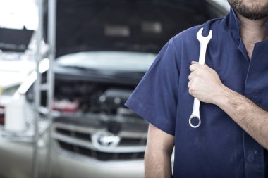 Garajdaki tamirci motoru tamir ediyor.