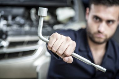 Garajdaki tamirci motoru tamir ediyor.