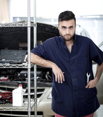 Garajdaki tamirci motoru tamir ediyor.